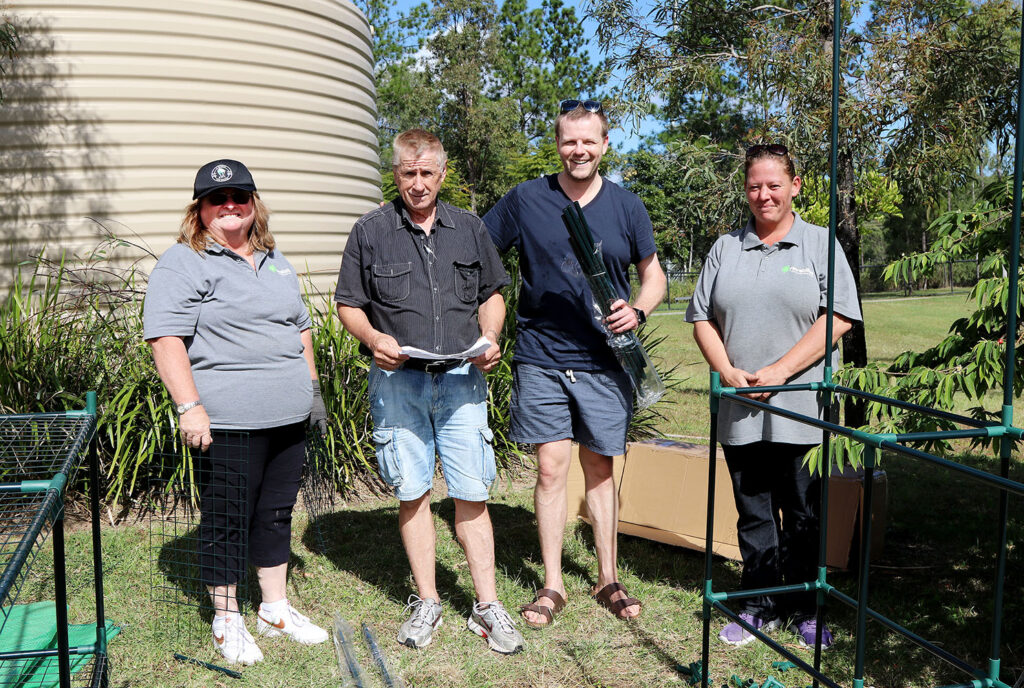 Volunteers build a greenhouse at the Gardens