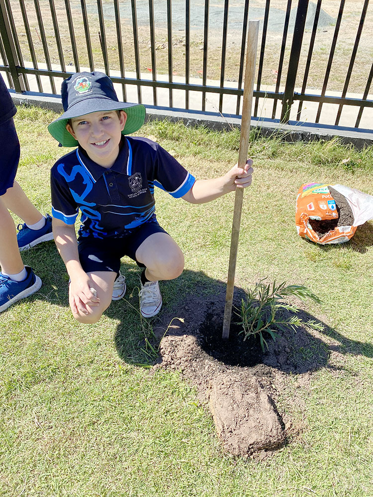 Student from Logan Village State School planting a native tree