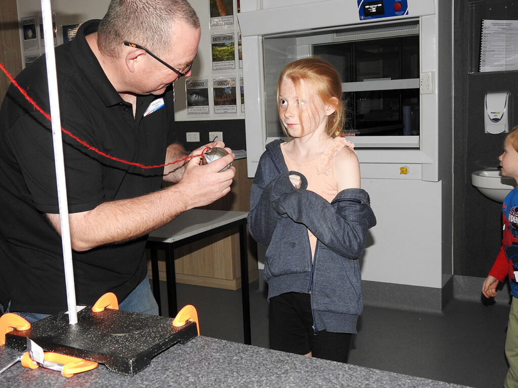 Mr Heeney demonstrating the science of physics to Amelia